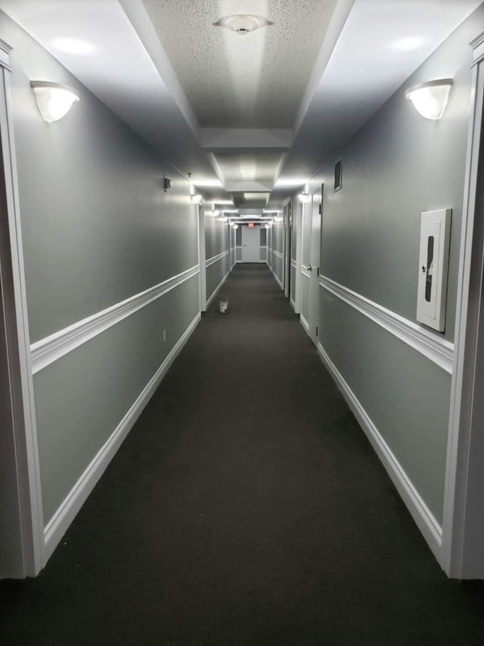 Long interior corridor painting project with crisp lines in Calgary building