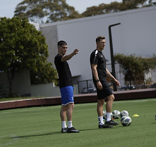 Coach Jan and a player on a football pitch