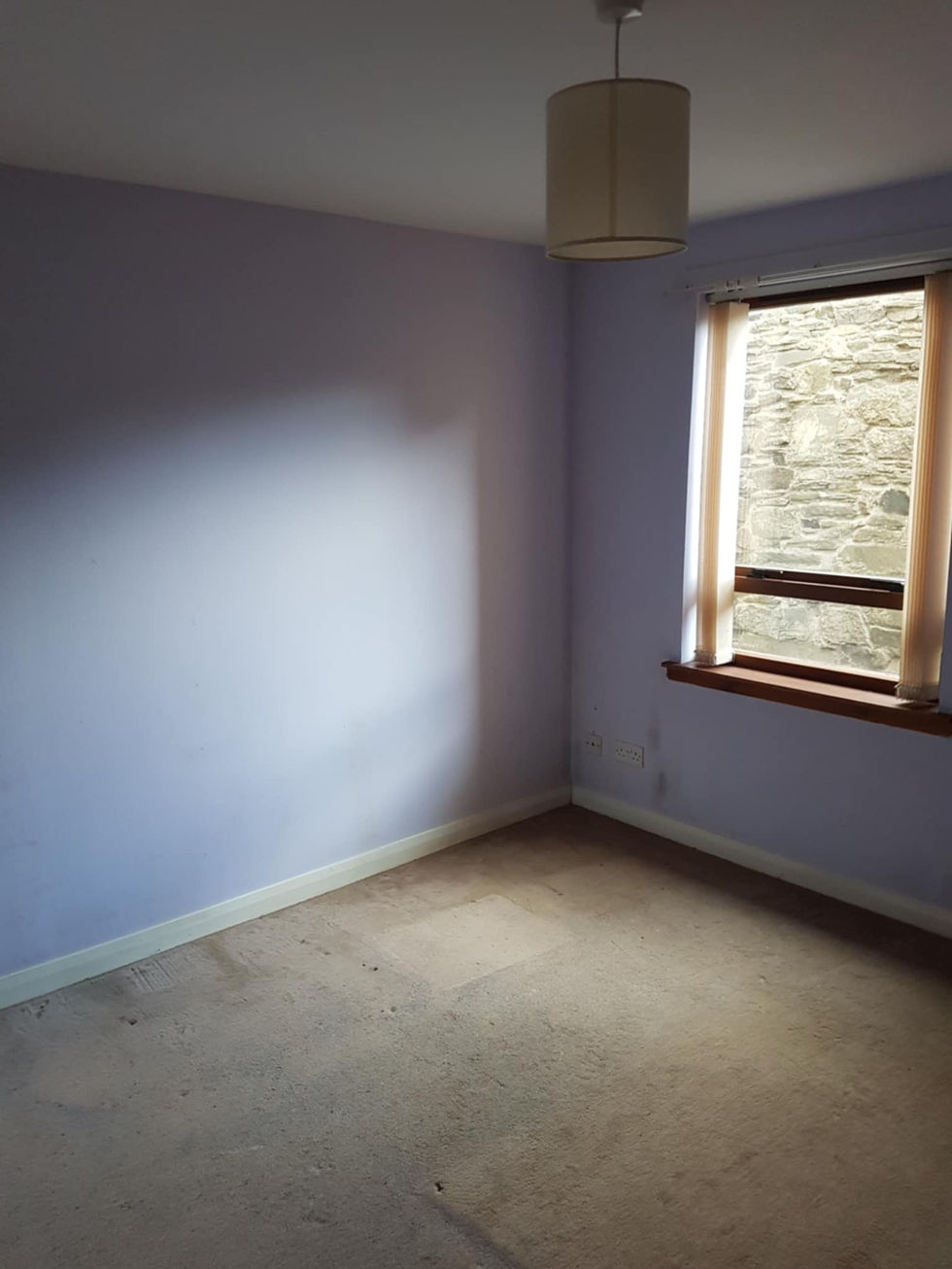 an empty room with purple walls and a window