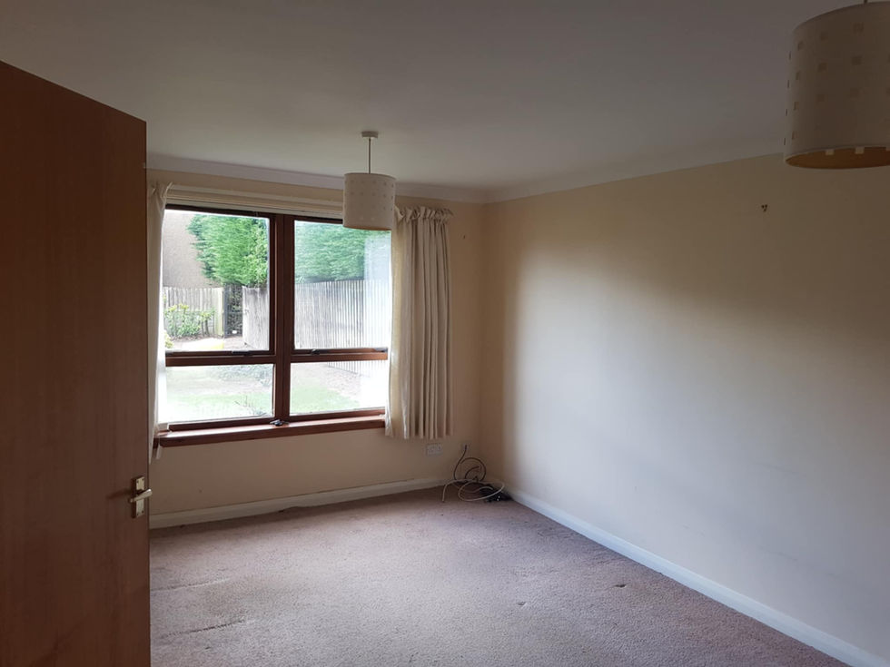 an empty room with a window and curtains