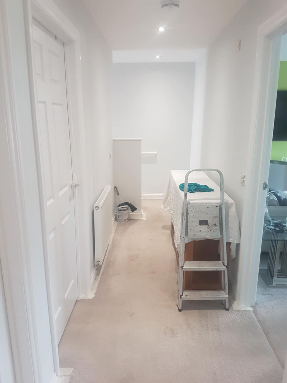 White hallway, treatment bed, and stairs