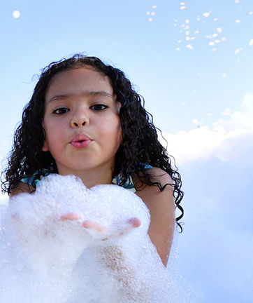 Child holding bubbles at a kids foam party