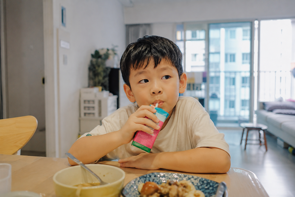 Child drinking a sweetened packet drink, a common source of hidden sugar for children in Singapore