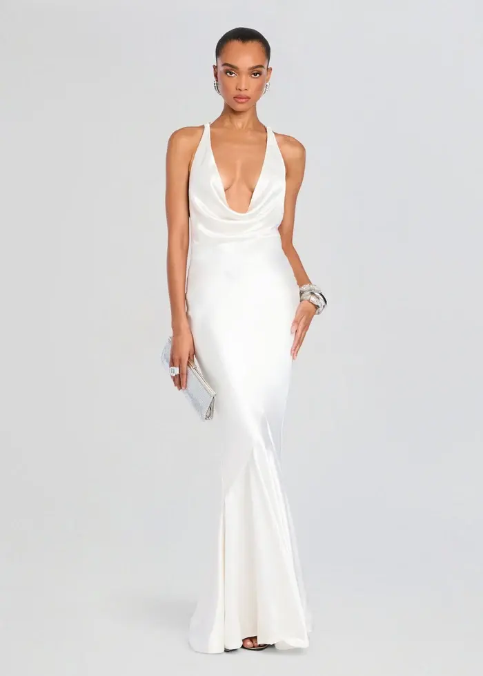 white halter gown with a plunging cowl neckline and flowing floor-length skirt for a wedding reception.