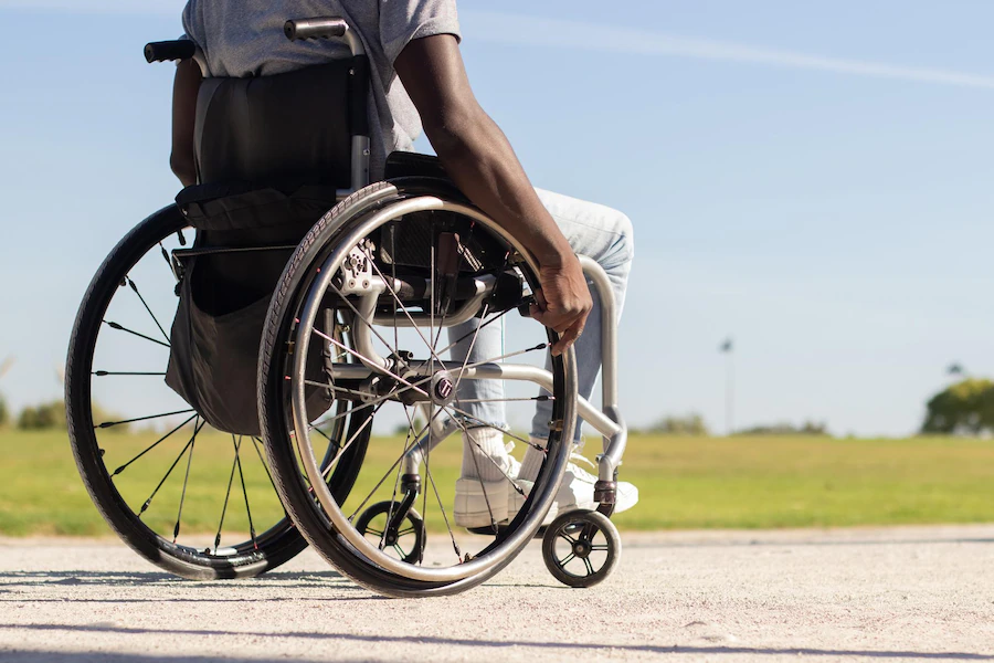 black-man-wheelchair-riding-along-park-road_74855-22191.webp
