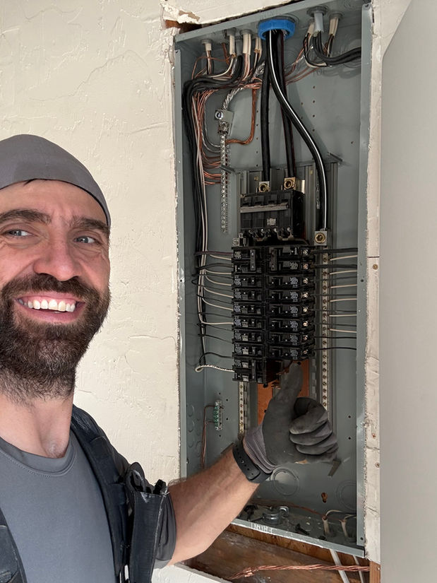 Dimitri Thevenin standing beside a completed residential electrical panel upgrade in Corvallis, Oregon.