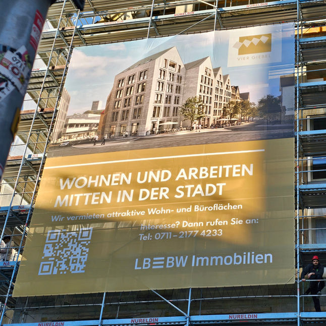 Ein großes Werbebanner an einem Baugerüst.
