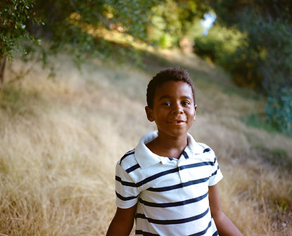 A young boy smiling in a field 