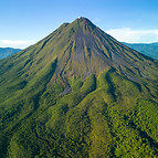 A scenic aerial view of Arenal Volcano in Costa Rica with lush green vegetation and clear 