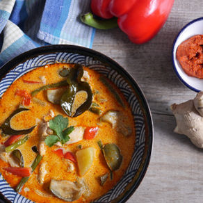 Soupe de curry rouge thaï au poulet servie chaude, une soupe thaïlandaise au lait de coco parfumée, aux légumes et aux épicesdans un bol avec du gingembre et poivron rouge