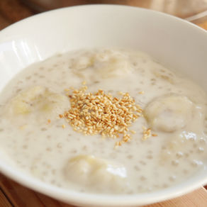 Perles de tapioca au lait de coco et bananes servies dans un bol blanc, texture crémeuse et perles translucides visibles, dessert exotique sans gluten.