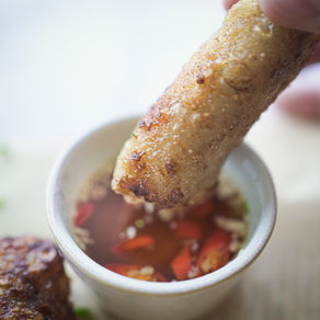 Nem doré et croustillant trempé dans une sauce Nuoc Cham maison.