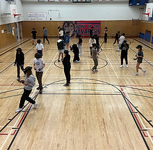 Schulklasse in der Turnhalle mit VR Headsets.png