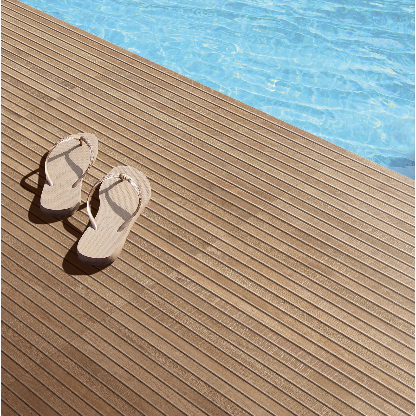 Swimming Pool Teak Wood Deck with 1 pair of sandals near pool blue transparent water.