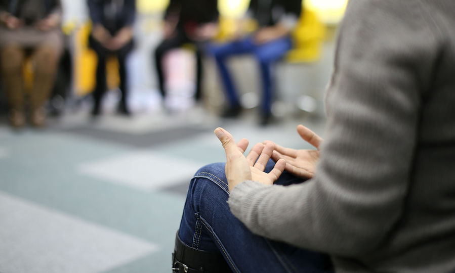 Person gestures while speaking during a group therapy session.