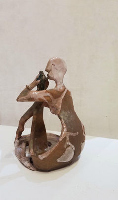 Sculpture toute en légèreté d'une femme jouant de la flûte