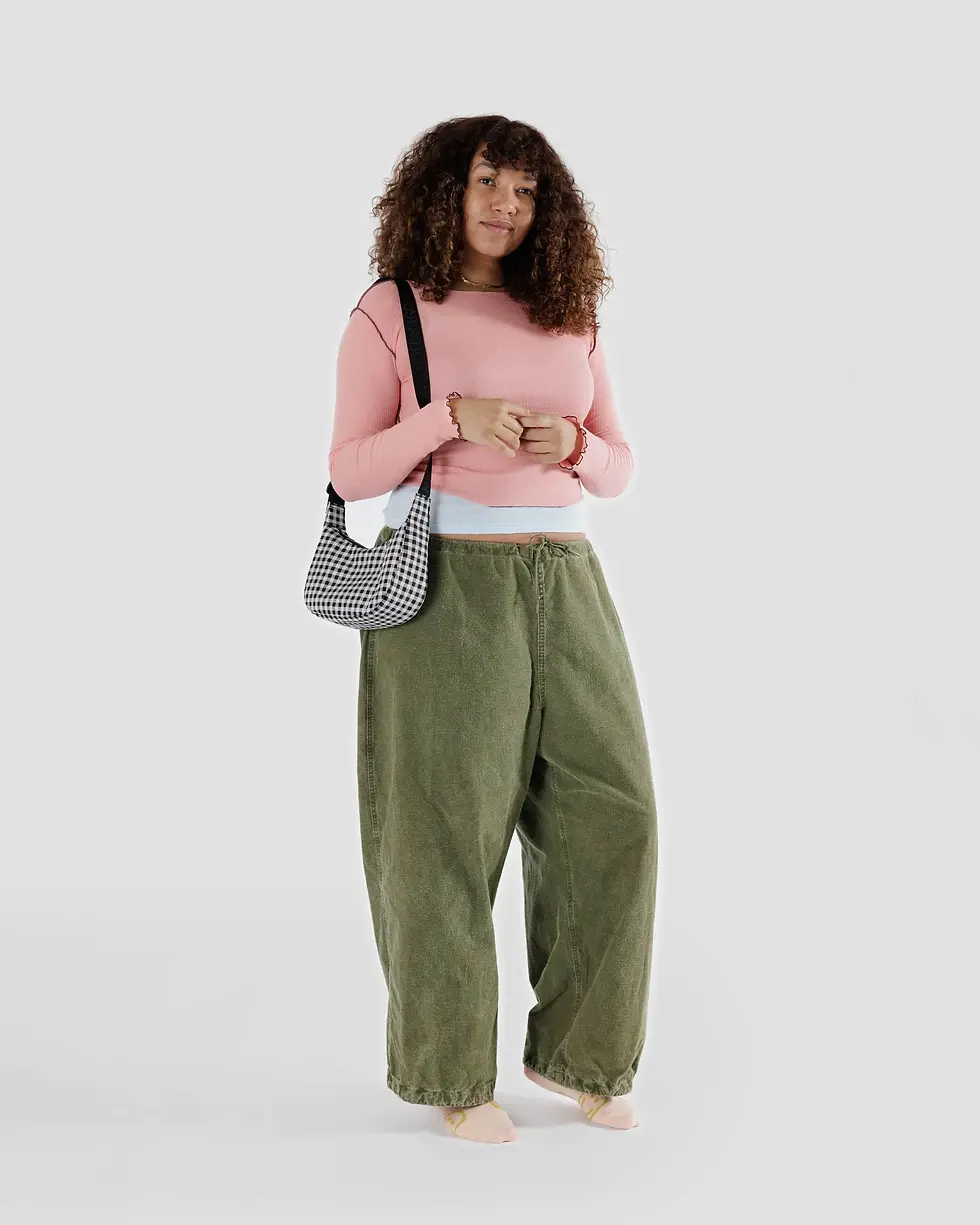 Thumbnail: Ansicht, wie eine Frau die BAGGU Small Nylon Crescent Bag Black & White Gingham trägt