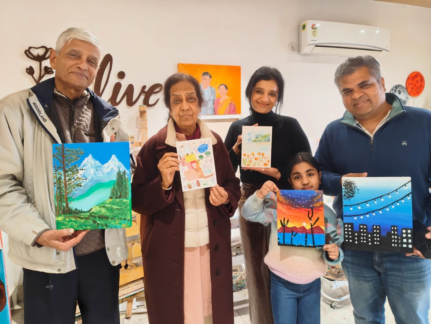 Family and friends with finished paintings at Alive Studio