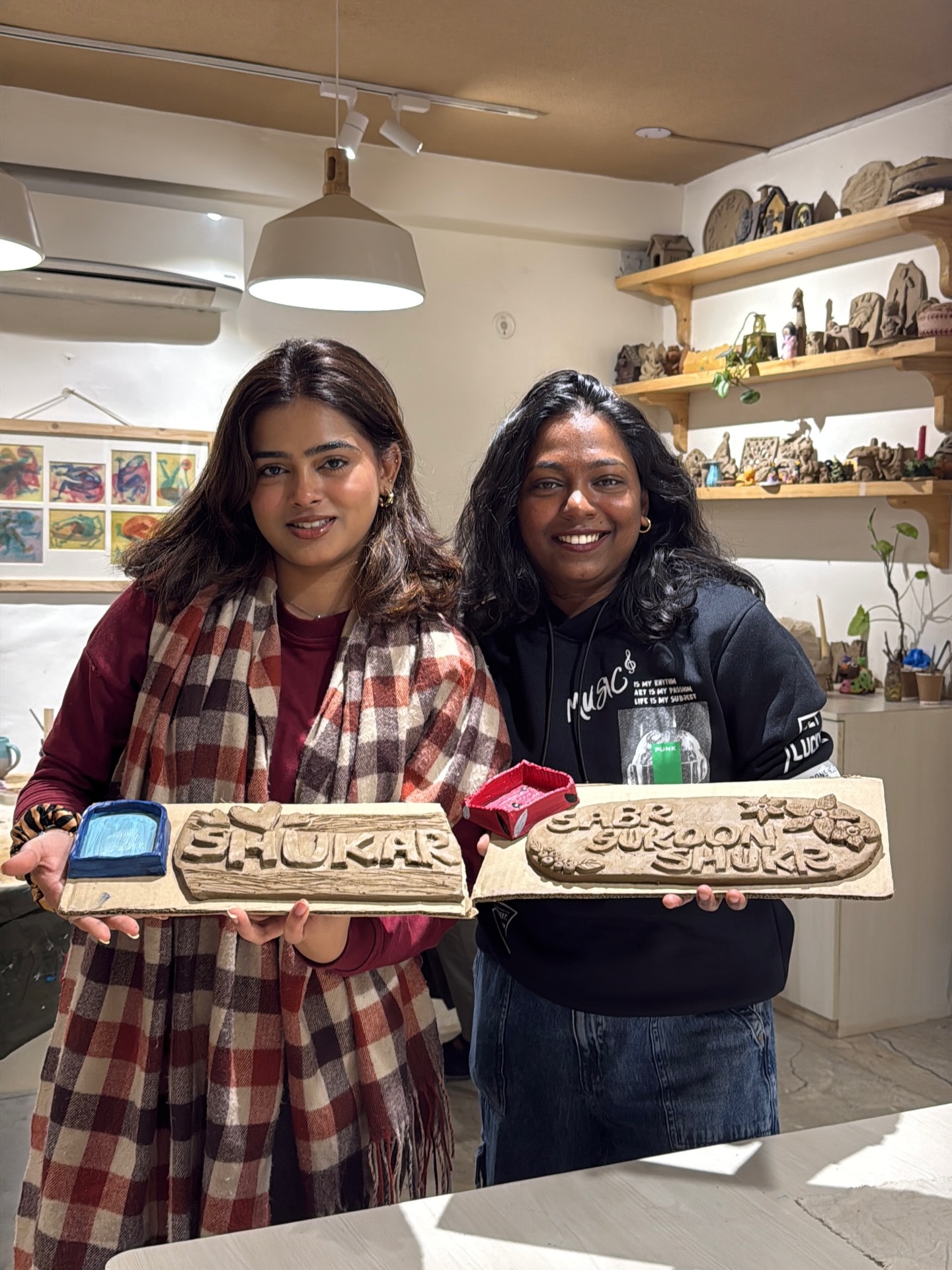Guests with finished clay name pieces at Alive Studio