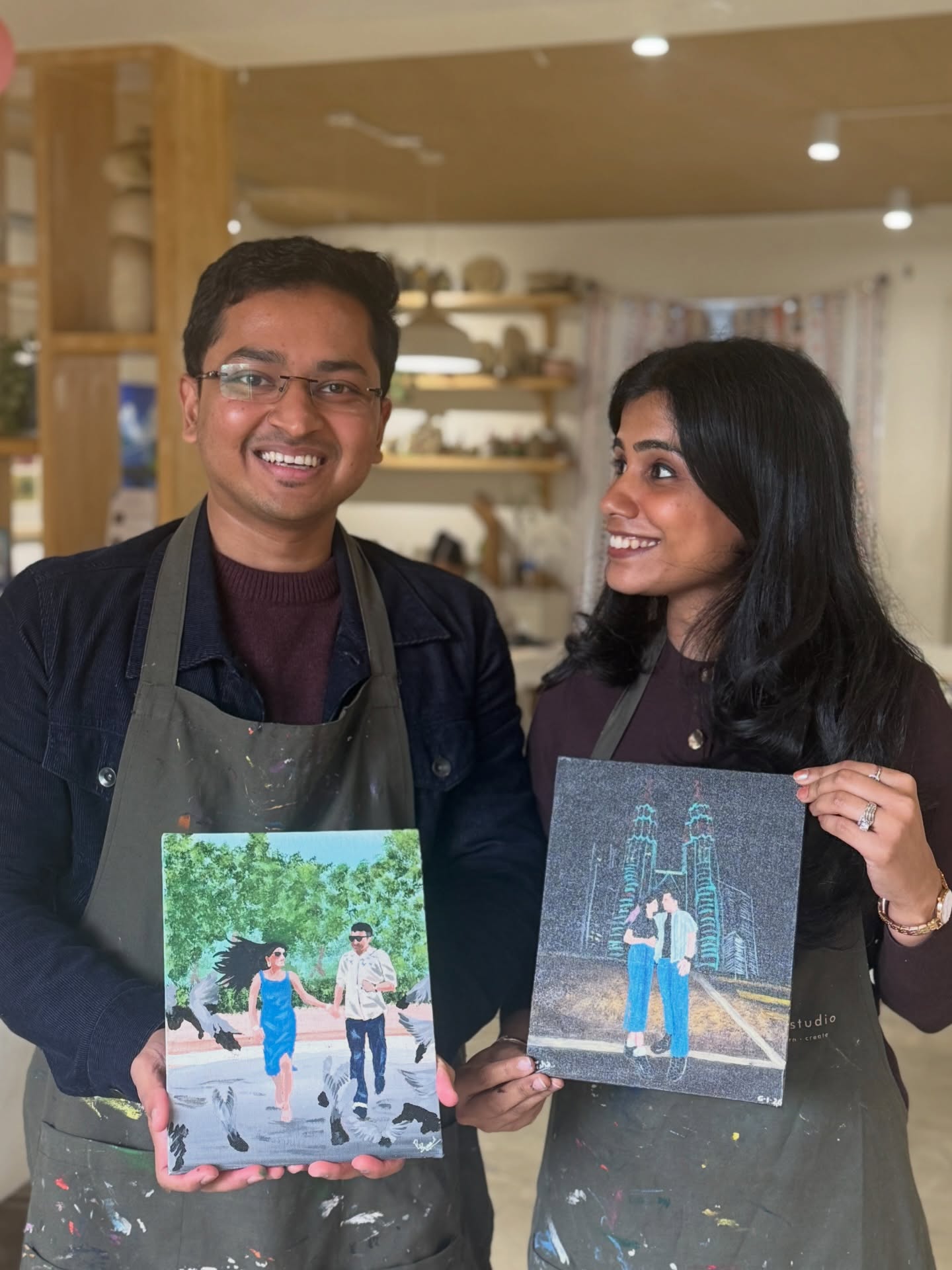 A couple with finished landscape paintings at Alive Studio