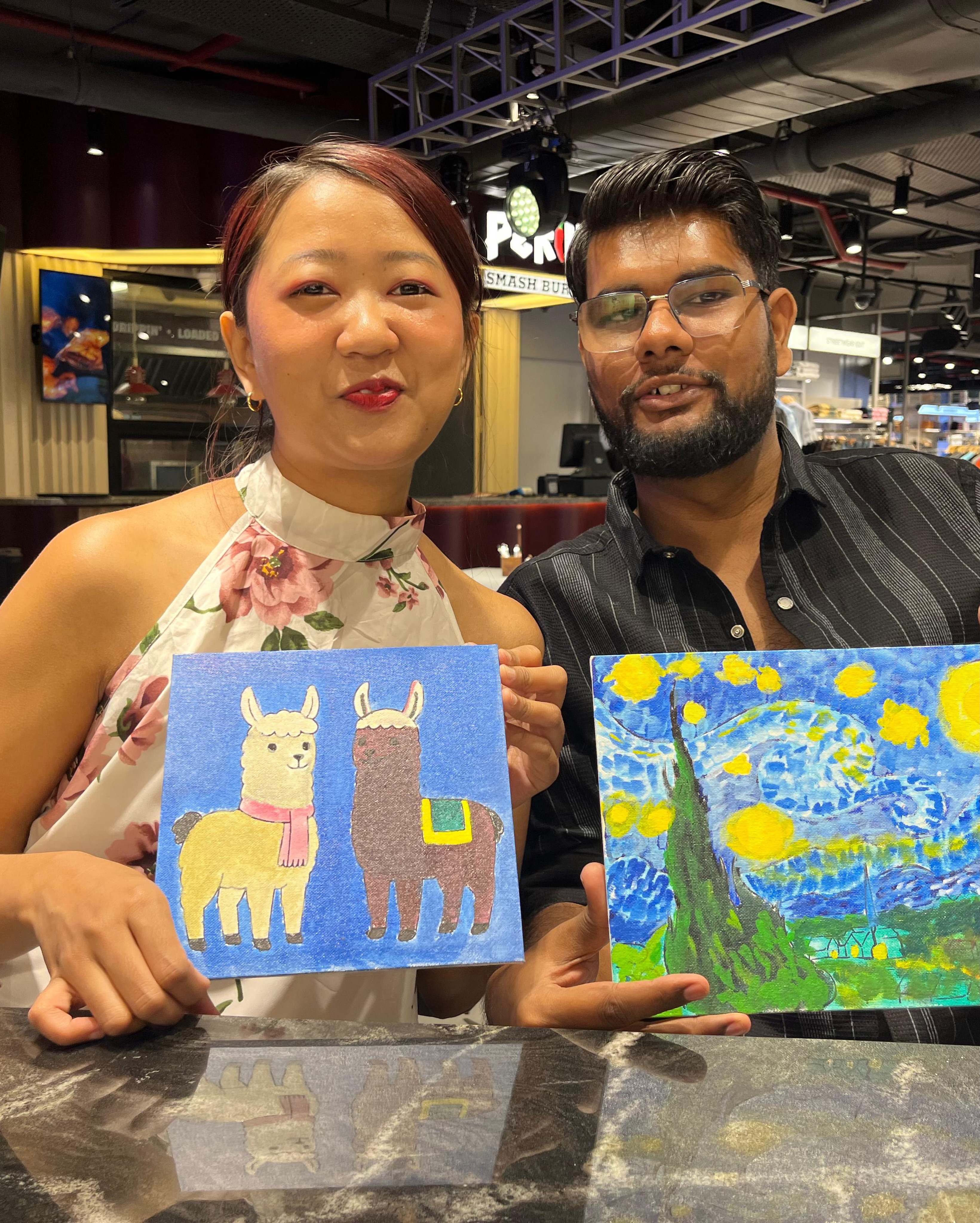 Couple with Llama and Starry Night canvases at Delhi Art Cafe