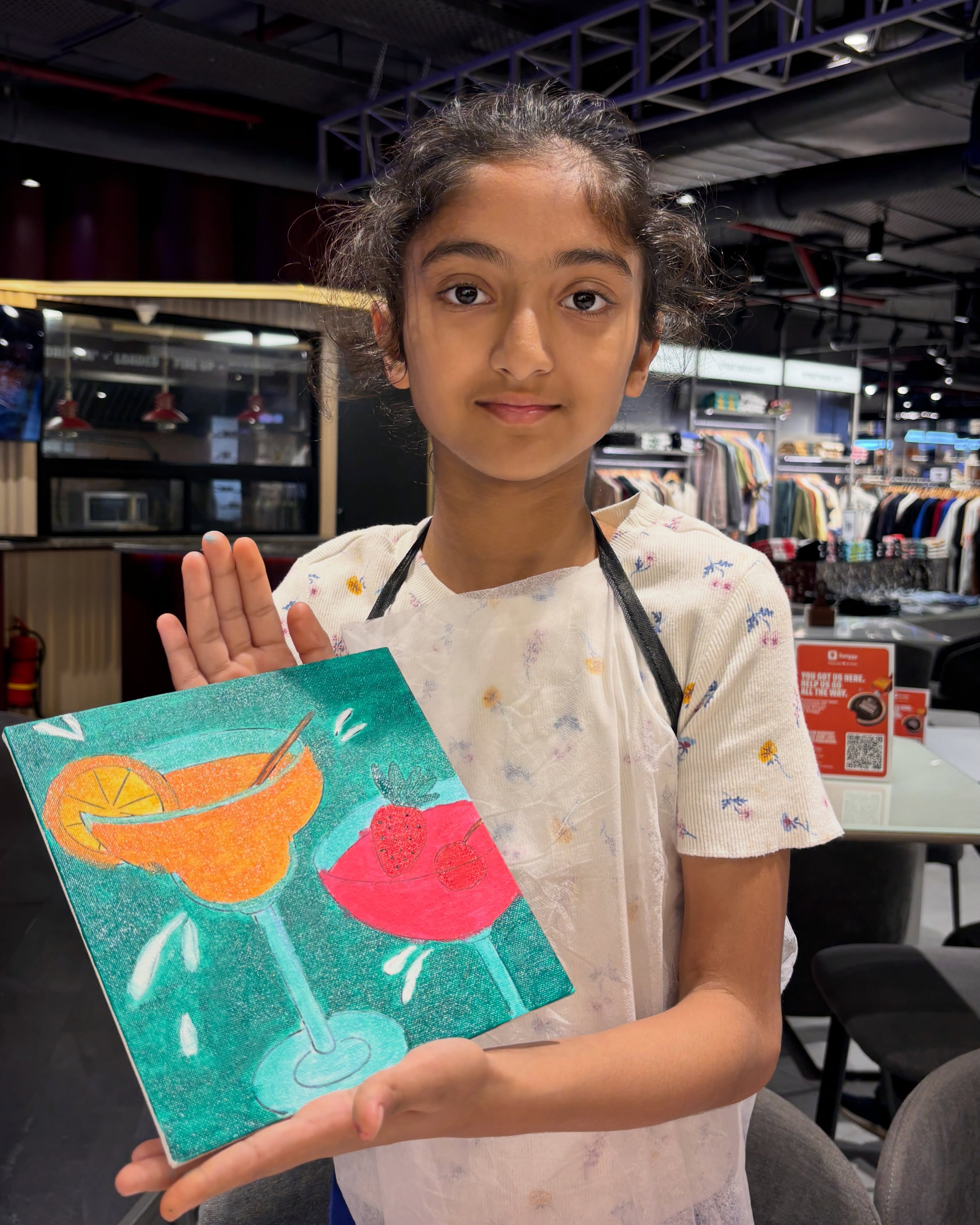 A young guest with a colourful canvas at Delhi Art Cafe