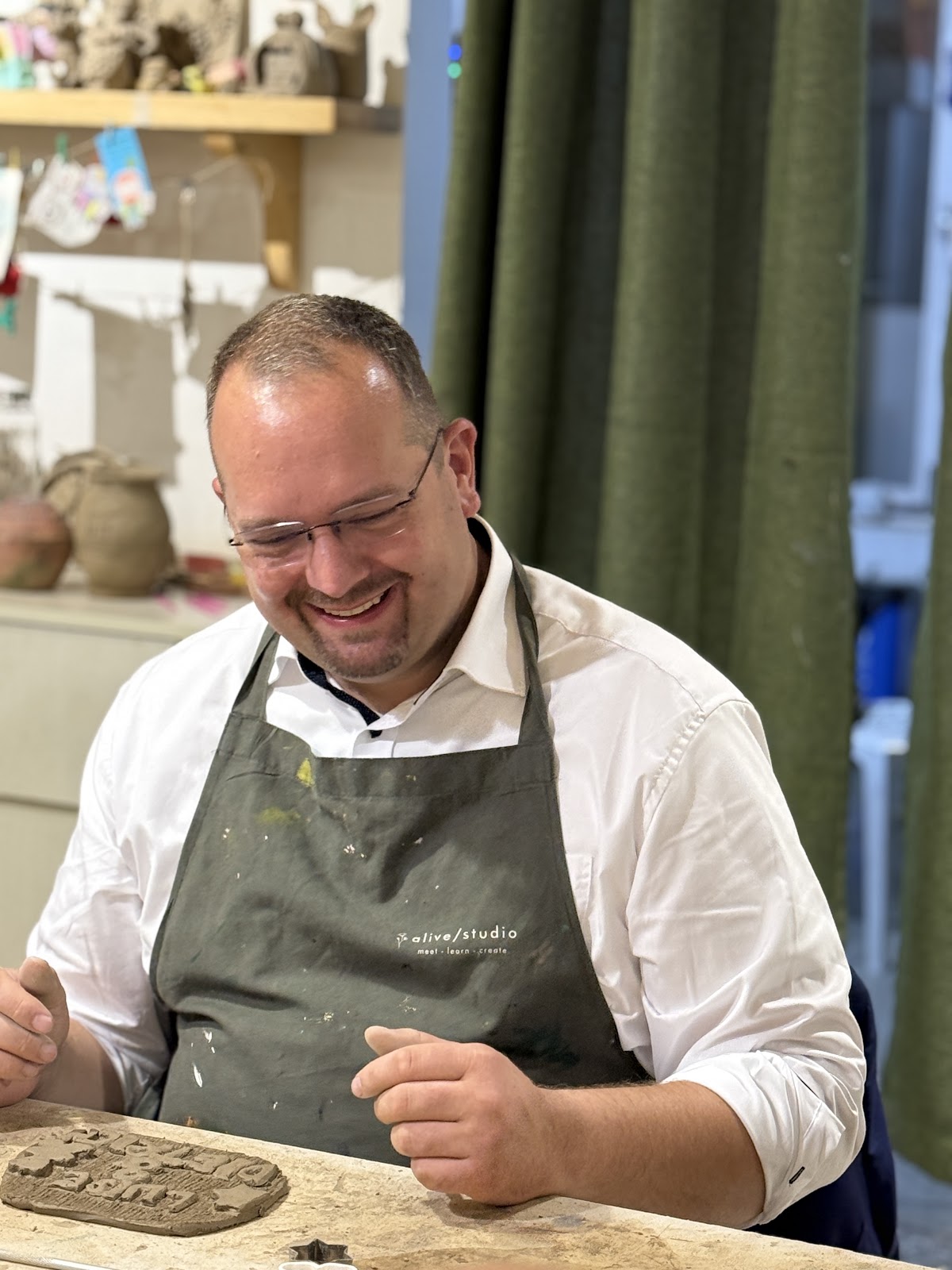 Smiling over a clay project at a team workshop