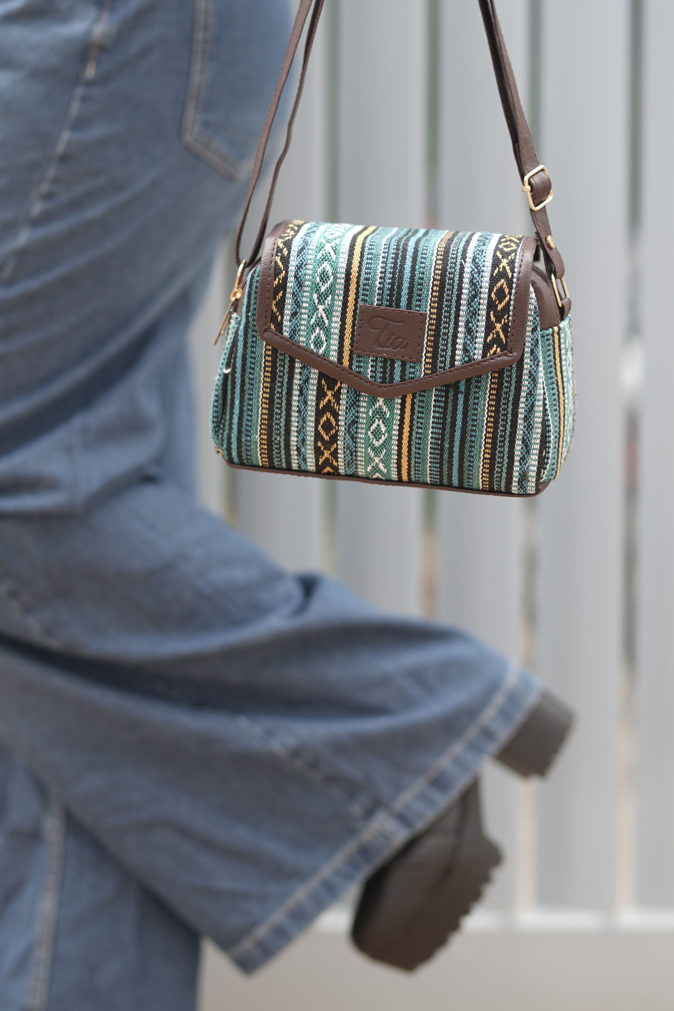 Woman holding Tia Half-Round Ethnic Sling Bag for Women – Single Compartment Crossbody. Tiabags