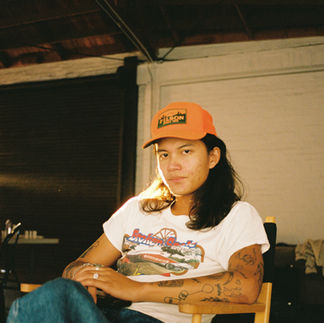 man sitting in directors chair on set, shot on film