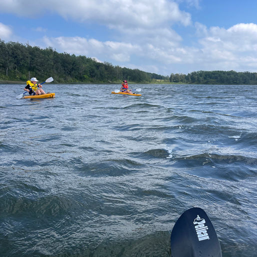 A person's perspective while paddleboarding on choppy water.
