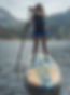 Woman standup paddleboarding on a lake.