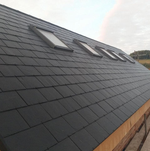 'After' photo of work carried out on black tiled roof by LMT Roofing and Building Ltd