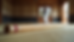 Eye-level view of a bo staff resting on a tatami mat in a dojo