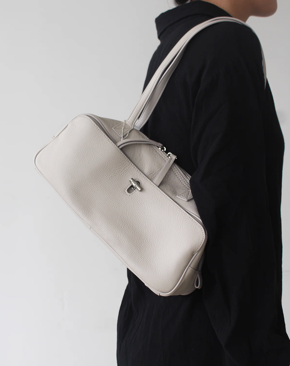 Horn buttoned toga embossed calf leather baguette shoulder handle bag