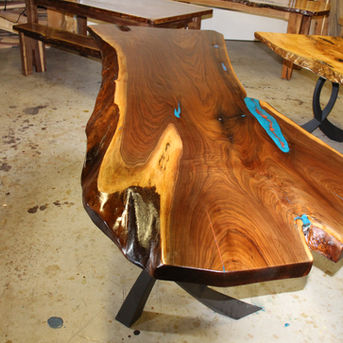 Close-up of live edge slab with blue epoxy filling natural wood voids