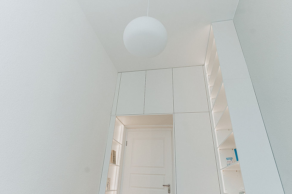 Blick nach oben zur Zimmerdecke, ein weißer Einbauschrank und eine runde Zimmerlampe
