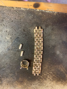 Close-up of jeweler hand-assembling and shaping a gold Panther Link ring.