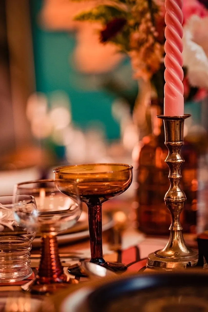 Wedding breakfast table, decorated with glassware and candles. Supplied and decorated by Disco Dining, an LGBTQ+ wedding supplier part of the Rebel Love Directory