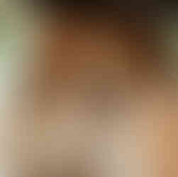 Lesbian couple on their wedding day smiling at each other with colourful bouquets captured by Feminist & LGBTQ+ wedding photographer, Rebel Love Club