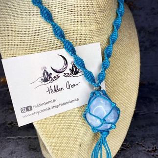 Blue rope style necklace holding a white, irredescent crystal stone. Hidden Gem is a LGBTQ+ Favours & gifts wedding supplier, part of the Rebel Love Directory.
