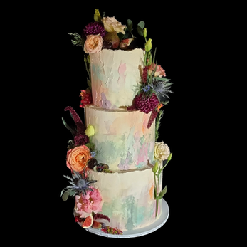 , three tier wedding cake with paste coloured icing, decorated with colorful flowers. Queer owned cake bakers Ahh Toots provide LGBTQ+ Inclusive Wedding Cakes, part of Rebel Love Directory