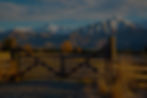 AclosedwoodenfarmgateattheentrancetoafarminthehighcountrybelowsnowymountainsSpringfieldNew