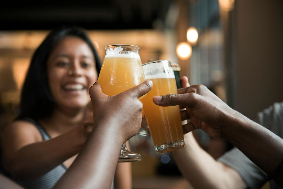 People toasting with beers; woman smiling in the background