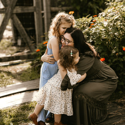 Mother and daughters hugging in outdoor Wilton, CT lifestyle photography session