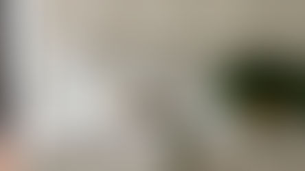 Integrated marble sink with vein-matched countertop and backsplash, brass faucet, and neutral cabinetry.