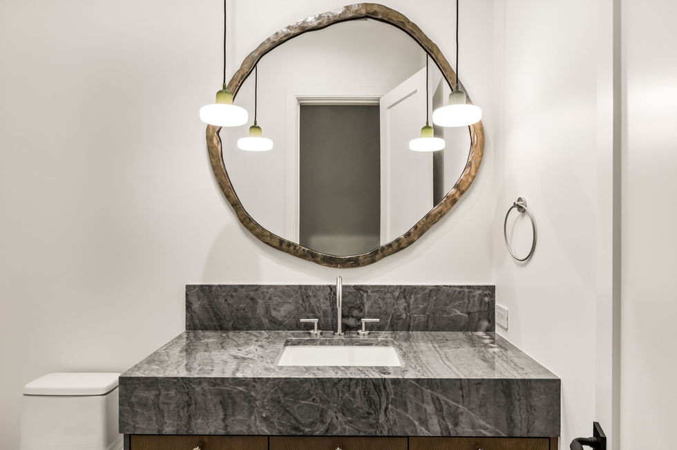 Refined vanity featuring mitered marble countertops and fluted wood cabinetry, crafted by Elegant Stone & Surfaces using ston
