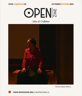La imagen es la portada de una publicación titulada "OPEN Zine", centrada en Artes y Cultura. Esta es la edición de octubre de 2023, etiquetada como "EJEMPLAR 05".

La portada presenta una fotografía de una mujer sentada en un banco de madera en una habitación tenue. Ella lleva una blusa roja y una falda oscura, y su cabello está recogido en un moño. La iluminación crea un efecto dramático, proyectando sombras y resaltando su expresión contemplativa mientras mira hacia un lado.

El fondo es oscuro y minimalista, sin distracciones visibles, lo que atrae la atención del espectador hacia la mujer y su pose pensativa. El ambiente general de la imagen es introspectivo y tranquilo, sugiriendo temas de reflexión o soledad.

El diseño es simple y elegante, con el enfoque completamente en el sujeto de la fotografía. El diseño limpio y los colores apagados contribuyen a la atmósfera serena y contemplativa de la portada.
