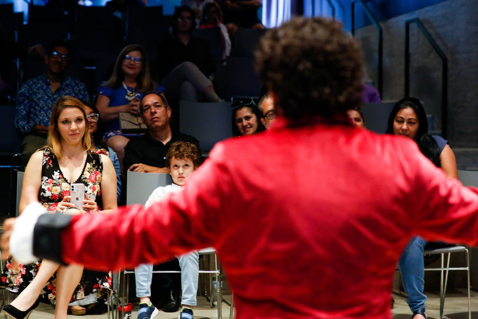 a man in a red jacket stands in front of a crowd of people
