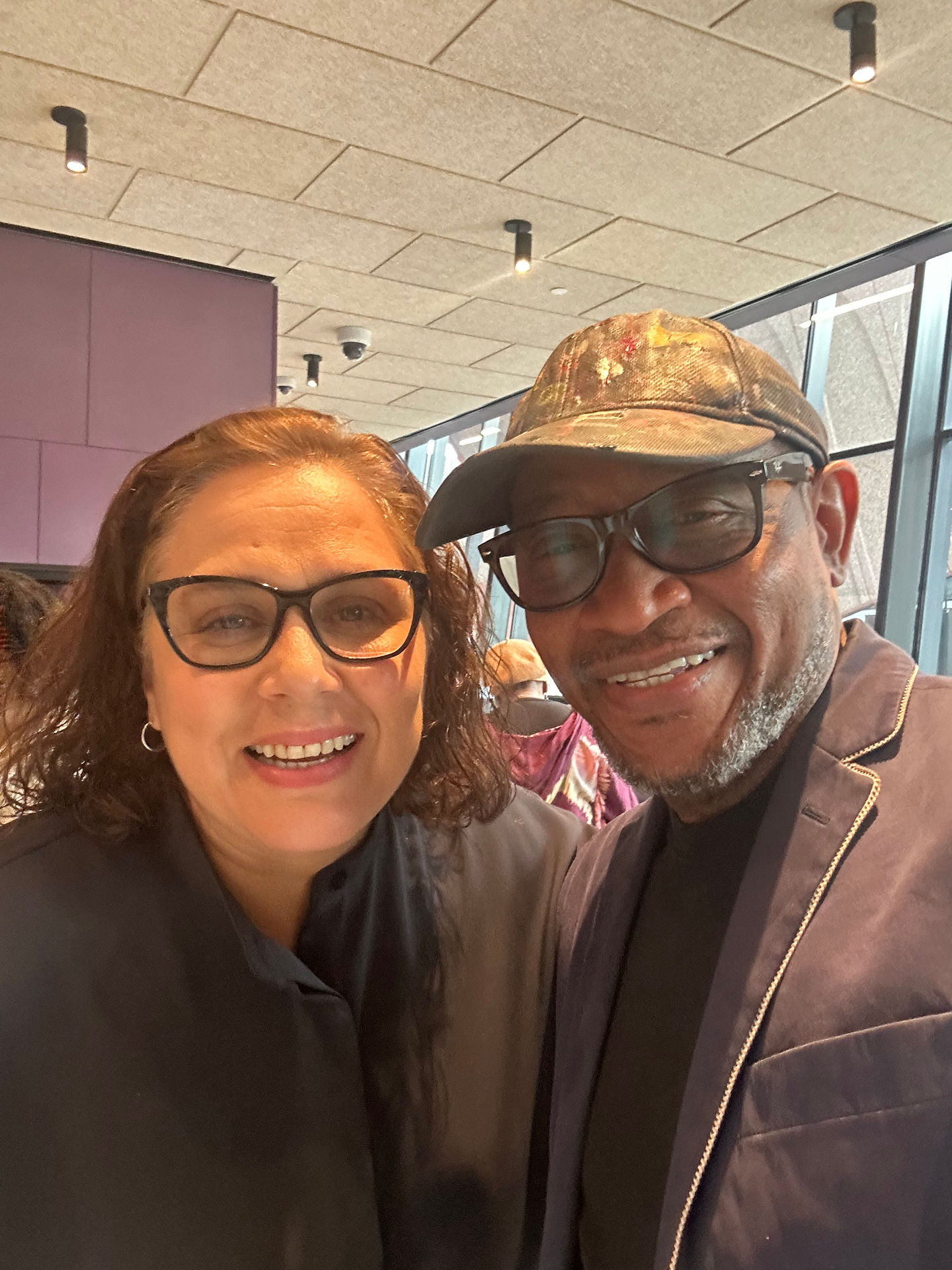 a man and a woman are posing for a picture and the woman is wearing glasses