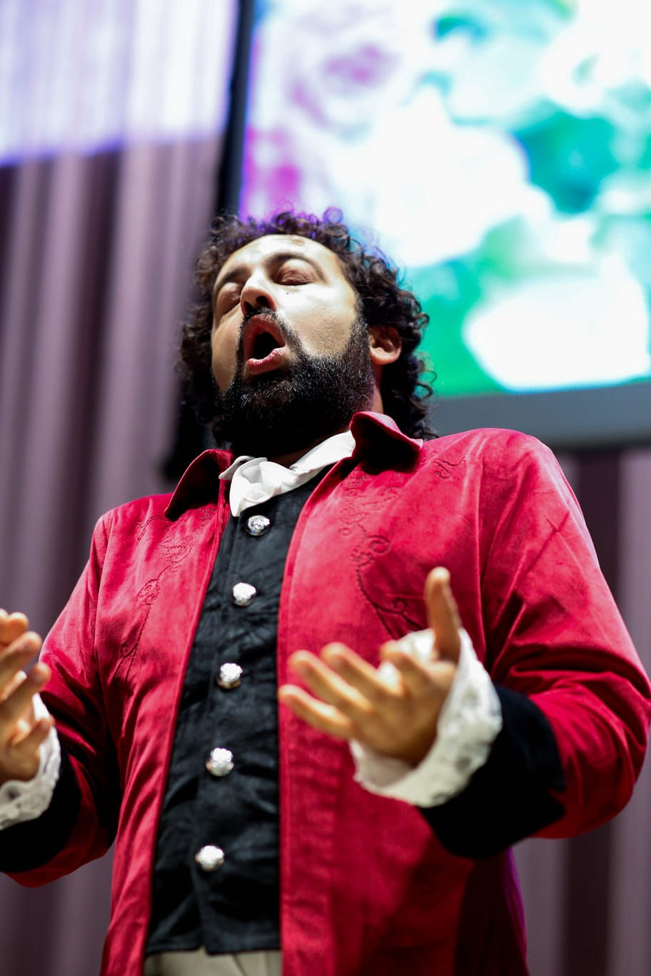 a man with a beard is wearing a red jacket